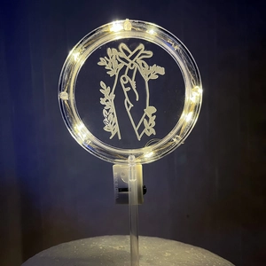 Detail of warm white LED acrylic cake topper with hand and flower pattern for Christmas
