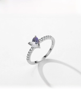 Gros plan d'une bague en argent S925 avec un zircon coloré en forme de cœur brillant
