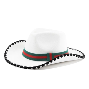 Detail of white felt cowboy hat featuring black stitched edge and striped ribbon band