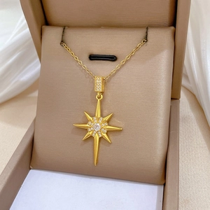 Detail of gold starburst pendant with sparkling diamonds in a luxury jewelry box