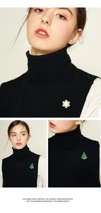 Macro view of cute metal snowflake and Christmas tree brooches on clothing