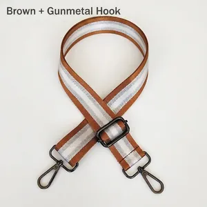 Detail view of adjustable nylon bag strap with silver stripes and gunmetal metal hooks