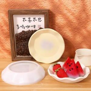 Moule en silicone pour bol à bords ondulés avec assiette en résine sur table en bois
