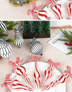 Detail of red and white striped Christmas ornaments with plaid bows on a festive tree