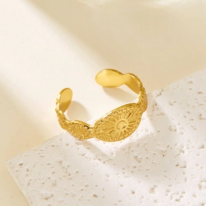 Detailed close-up of a gold-plated adjustable ring with vintage solar relief pattern