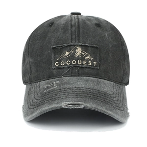 Close-up of vintage washed baseball cap featuring mountain embroidery patch and distressed brim