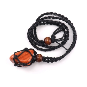 Detail of hand-woven black cord necklace with raw reddish stone and wood beads