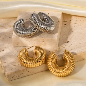 Luxury chunky ribbed stainless steel hoop earrings in gold and silver finish on stone