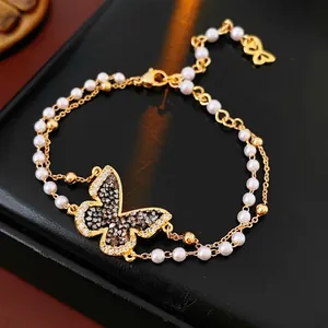 Elegant gold butterfly pearl bracelet with shimmering rhinestones on black background