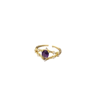 French style gold ring featuring a large purple pear-shaped zircon with intricate hollow metalwork