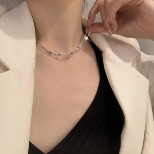 Close-up of double-layer silver titanium steel necklace with square beads on a model