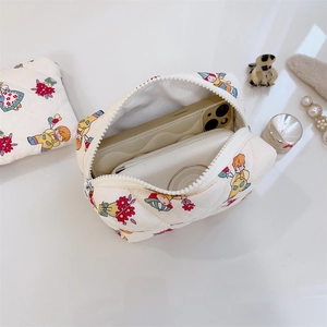 Internal view of a quilted cotton floral makeup bag holding cosmetic items and a phone