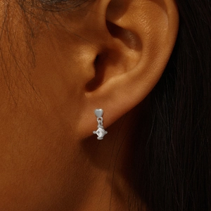 Close-up of s925 sterling silver heart-shaped ear stud with a hanging geometric zircon pendant
