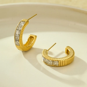 Detail of 18K gold plated C-shaped earrings with vertical baguette-cut cubic zirconia