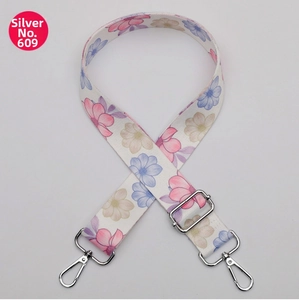 Detail of floral printed bag strap with silver metal lobster clasps and buckle