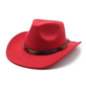 Detail of red cowboy hat featuring black decorative band with blue arrow embroidery