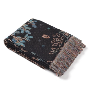 Detail of woven jacquard blanket showing vintage leaf pattern and colorful tassels