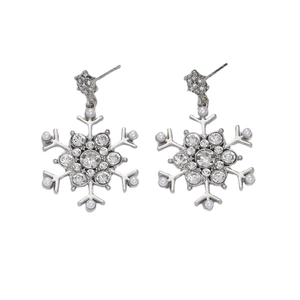 Macro detail of snowflake drop earrings with sparkling crystals and elegant white pearls