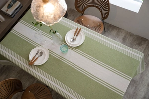 Top view of green and beige striped tablecloth on a rectangular dining table for two