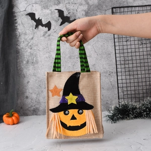 Detail of linen Halloween gift bag featuring a cute 3D pumpkin witch with striped handle