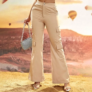 Detail of khaki high-waisted cargo flare pants with large side pockets in desert setting
