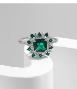Macro shot of emerald-cut green gemstone ring with halo cluster of diamonds on S925 silver