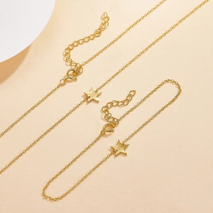 Macro shot of minimalist gold five-pointed star pendant on delicate chain jewelry set