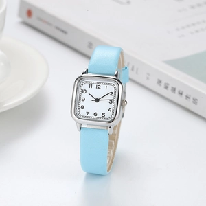 Montre femme chic avec boîtier carré argenté et bracelet en cuir bleu clair dans un décor
