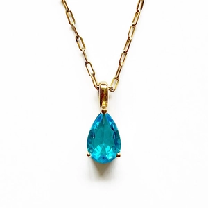 Collar de acero de titanio con colgante de circonita azul en forma de pera y cadena dorada