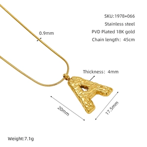 Detail of 18K gold plated letter A pendant with hammered texture on snake chain