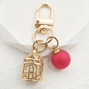 Creative birdcage pearl and red bead keychain in gold alloy finish for bags