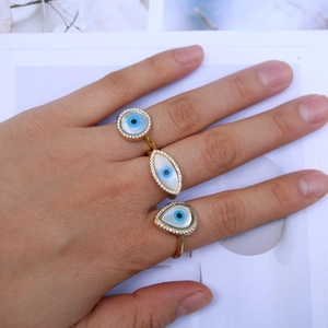 Detail of evil eye open rings with gold plating, zircon inlay and shell accents