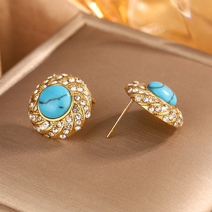 Macro view of gold 18k titanium steel stud earrings with turquoise and white rhinestones