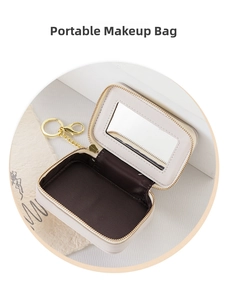 Close-up of portable mini makeup bag with interior mirror and golden metal keychain hook