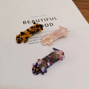 Detail of cat hair clips in tortoiseshell and marble patterns with gold accents