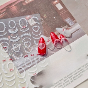 Detail of vintage lace nail stickers with red polka dots and heart patterns on art paper