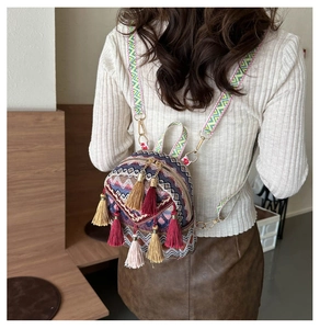 Close-up of bohemian mini backpack with colorful fringe tassels and woven straps
