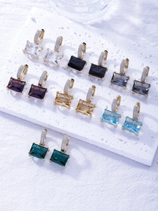 Detailed macro view of colorful rectangular zircon earrings with gold micro-pave setting