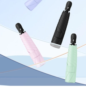 Close-up of portable automatic folding umbrellas in pink black and green colors