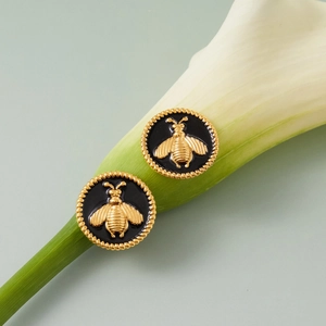 Boucles d'oreilles abeille dorée avec émail noir sur tige de lys calla blanc