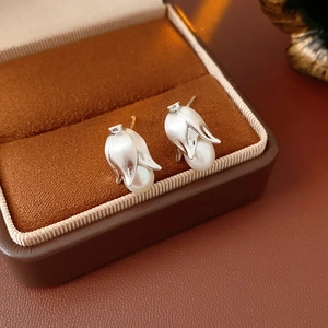 Close-up of French vintage silver tulip earrings with white pearls in a brown jewelry box