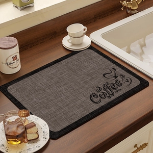 Absorbent coffee machine mat with vintage pattern on a dark wood kitchen countertop