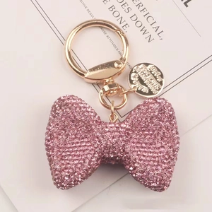 Dettaglio del portachiavi a fiocco con strass rosa e gancio dorato lucido
