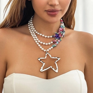 Detail of bohemian layered necklace with colorful beads, pearls and star pendant