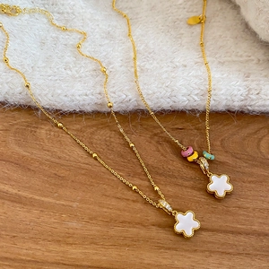 Detailed macro view of two-sided white floral clover necklaces with colorful enamel rings