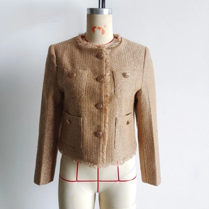 Nahaufnahme der braunen Tweed-Jacke mit Goldknöpfen und Fransenbesatz an den Kanten