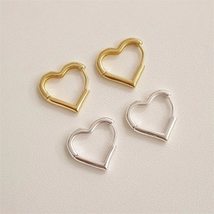 Detailed view of polished heart-shaped hoop earrings in gold and silver finishes