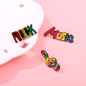 Rainbow music enamel pin set featuring ROCK, Music lettering and colorful treble clef symbol