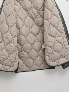 Detail of wave quilted lining and inner stitching on green diamond quilted cotton jacket