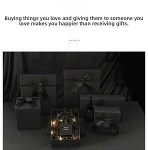 Detail of black gift box with satin ribbon, LED string lights, and internal filler material